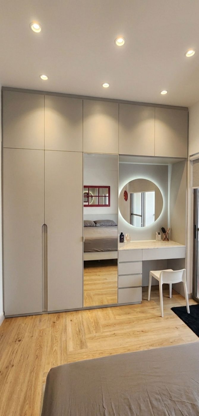 Wardrobe wall with full-length mirror and a vanity desk with a round lit mirror